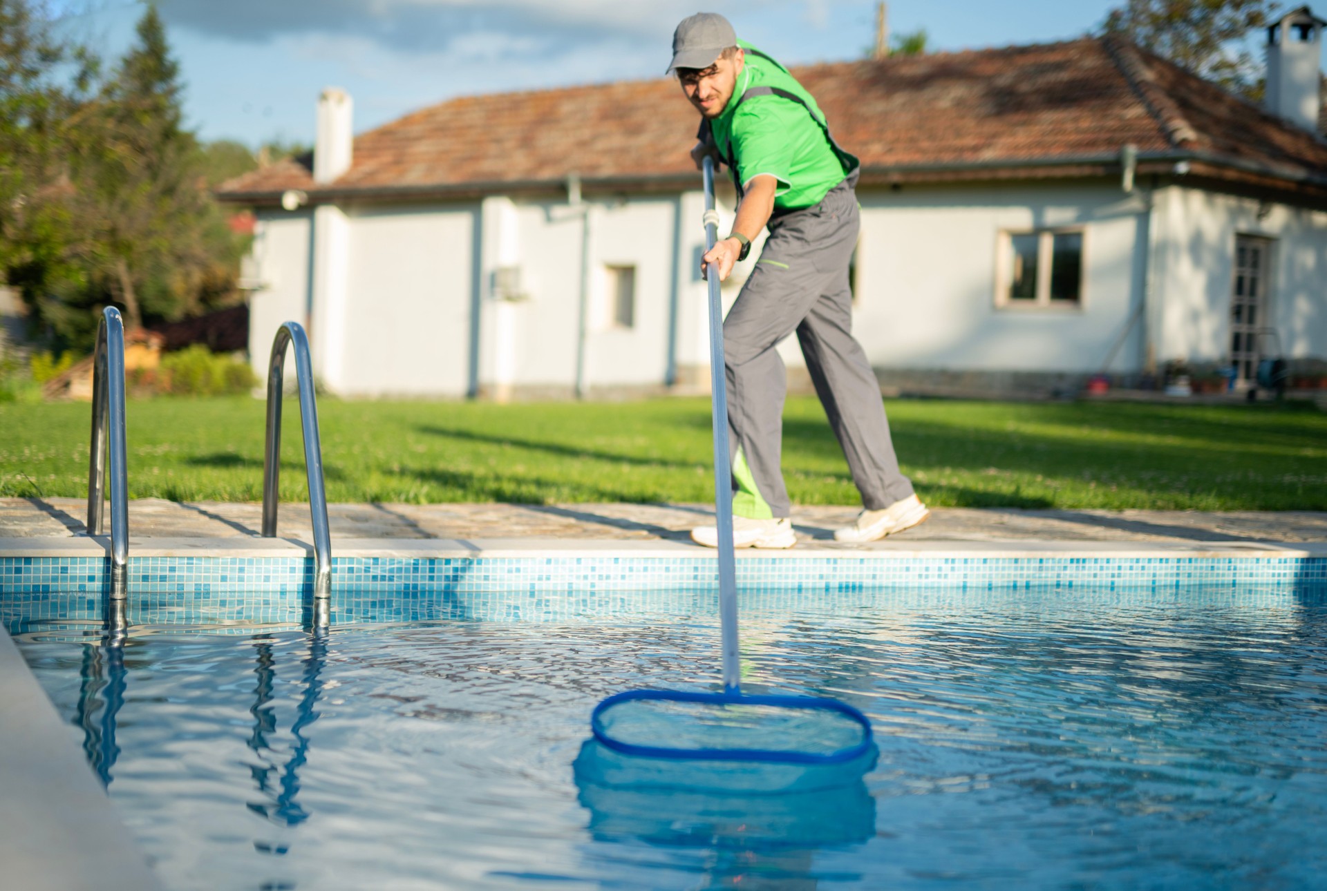 Swimming pools maintainer cleaning out one at a private home.